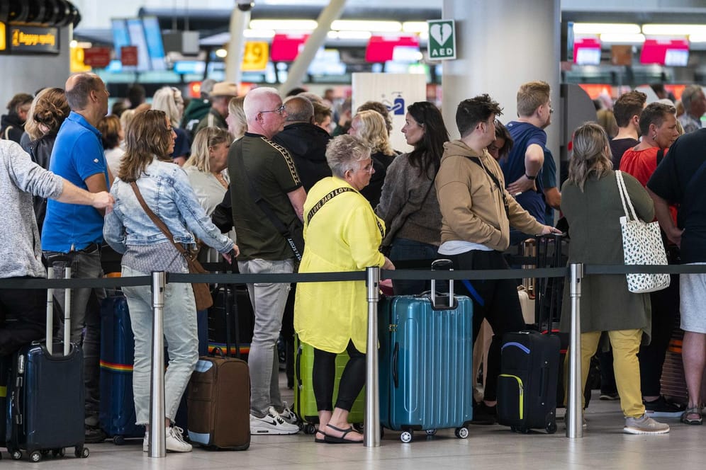 Reisende stehen in der Abflughalle des Flughafens Schiphol Schlange: Seit Wochen kämpft der Flughafen mit großen Problemen bei der Gepäckabfertigung und Sicherheit wegen Personalmangels.