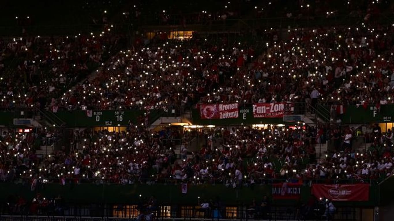 Zuschauer leuchten während des Stromausfalls im Ernst-Happel-Stadion mit ihren Mobiltelefonen.