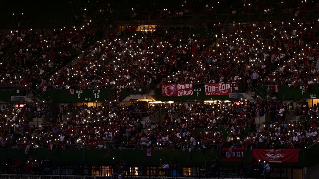 Zuschauer leuchten während des Stromausfalls im Ernst-Happel-Stadion mit ihren Mobiltelefonen. Zuschauer leuchten während des Stromausfalls im Ernst-Happel-Stadion mit ihren Mobiltelefonen.