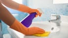 Badezimmer putzen: Reiniger aus einer Sprühflasche lassen sich besser auf den Oberflächen verteilen.
