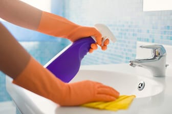 Badezimmer putzen: Reiniger aus einer Sprühflasche lassen sich besser auf den Oberflächen verteilen.