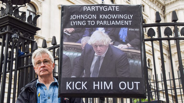 Protest vor der Downing Street: "Schmeißt ihn raus" fordert dieser Demonstrant und wirft Johnson im "Partygate" Lügen vor.