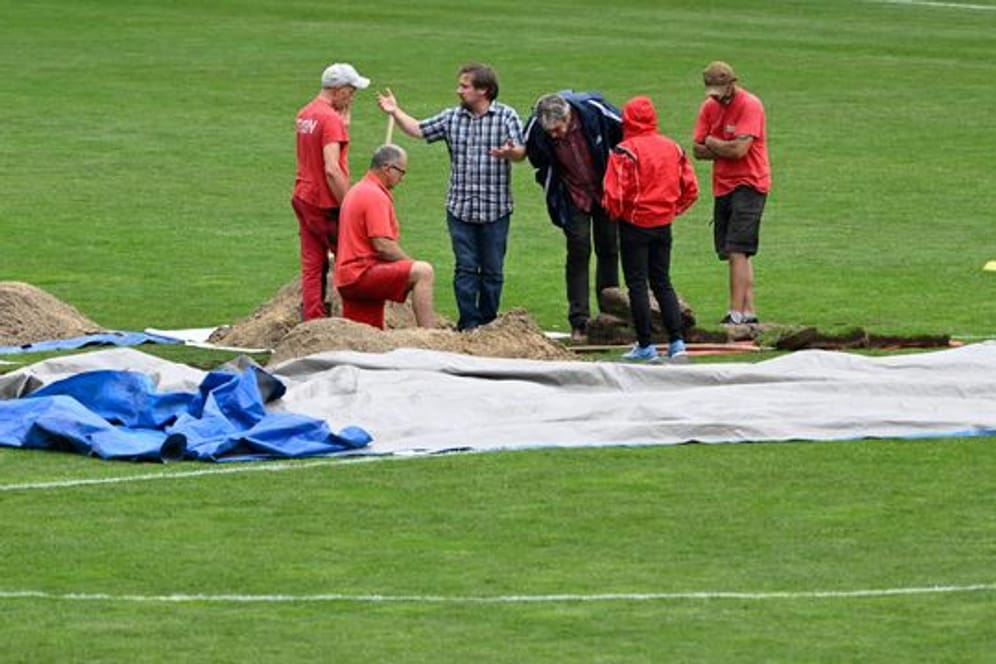 Arbeiter haben sich um das mysteriöse Loch im Rasen des Ernst-Happel-Stadions versammelt.