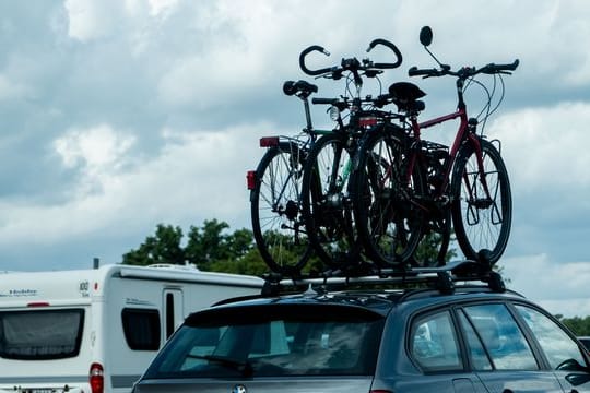 Rad auf dem Dach und plötzlich merkt man jeden Windzug von der Seite: Wer die Fahrräder mit dem Auto transportiert, muss sich auf ein anderes Fahrverhalten seines Autos einstellen.