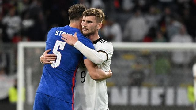 Englands John Stones und Deutschlands Timo Werner (r) umarmen sich nach dem Spiel.