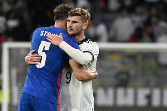 Englands John Stones und Deutschlands Timo Werner (r) umarmen sich nach dem Spiel.