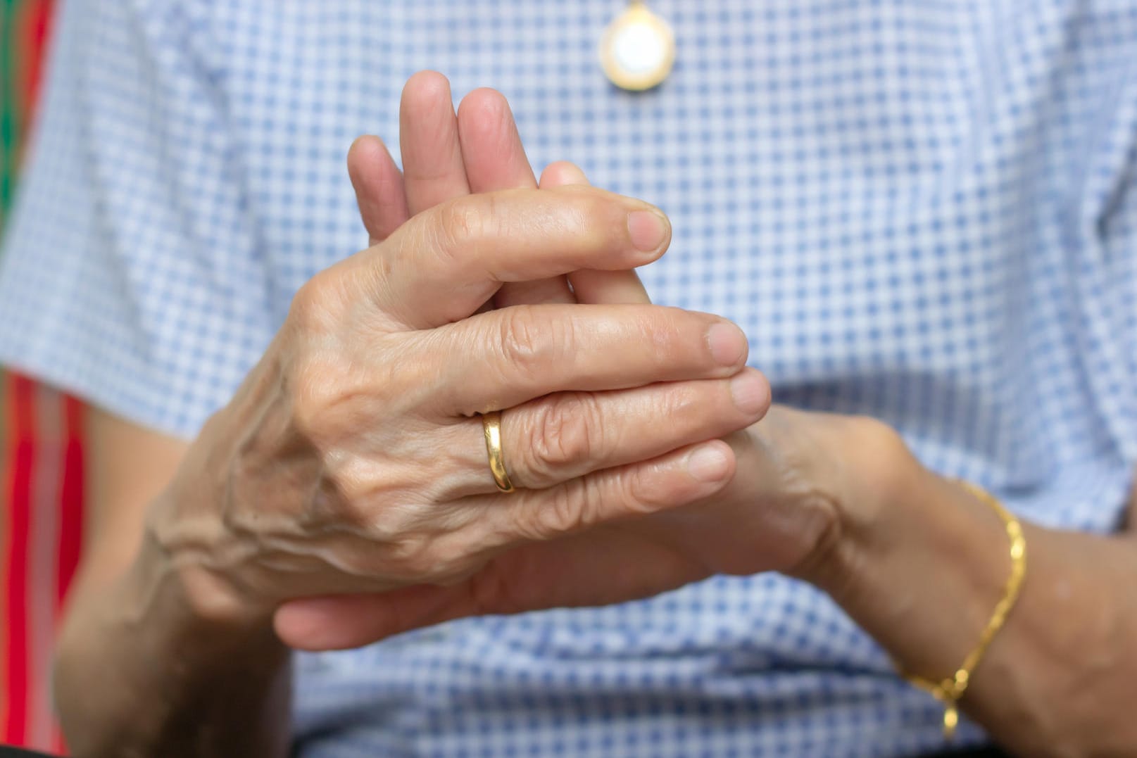 Eine Frau hält die Finger ihrer linken Hand umschlossen.