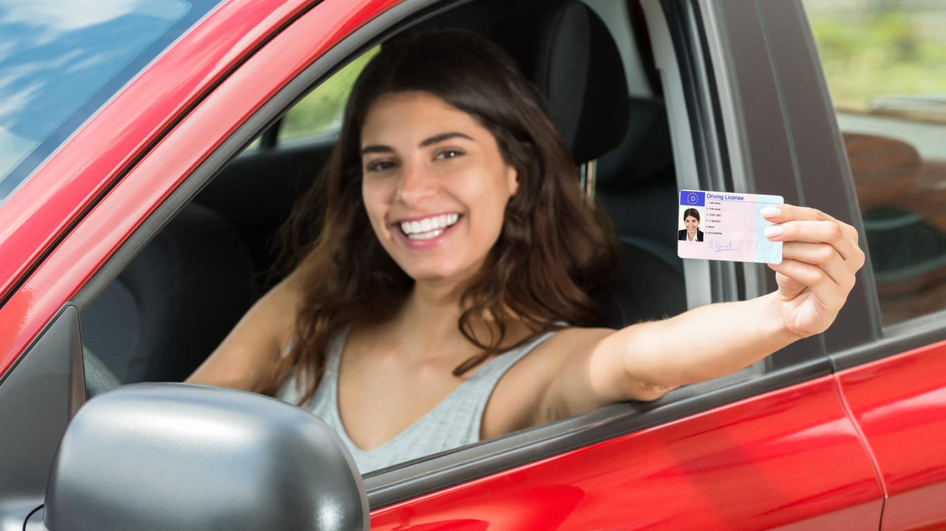 Junge Frau zeigt ihren Führerschein: Die Fahrerlaubnis ab 16 ist in Diskussion.