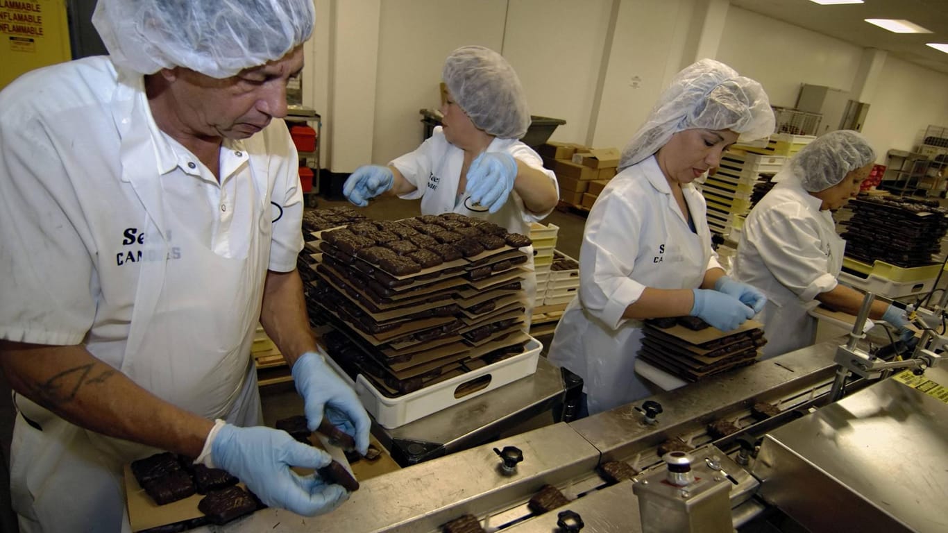 Arbeiter in einer Schokoladenfabrik (Symbolbild): Zwei Mitarbeiter von Mars mussten aus einem Tank gerettet werden.