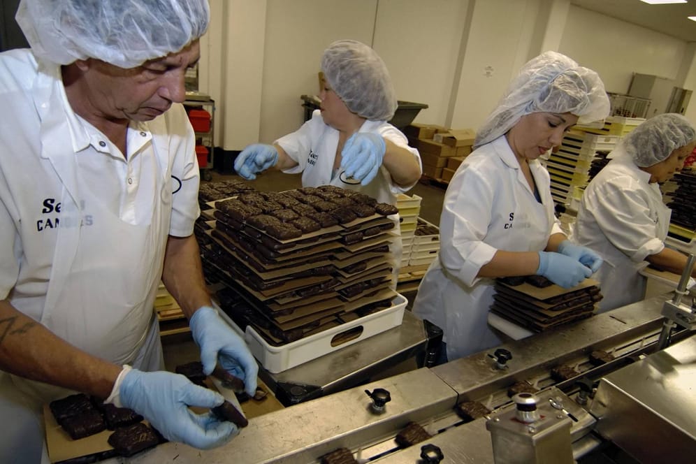 Arbeiter in einer Schokoladenfabrik (Symbolbild): Zwei Mitarbeiter von Mars mussten aus einem Tank gerettet werden.