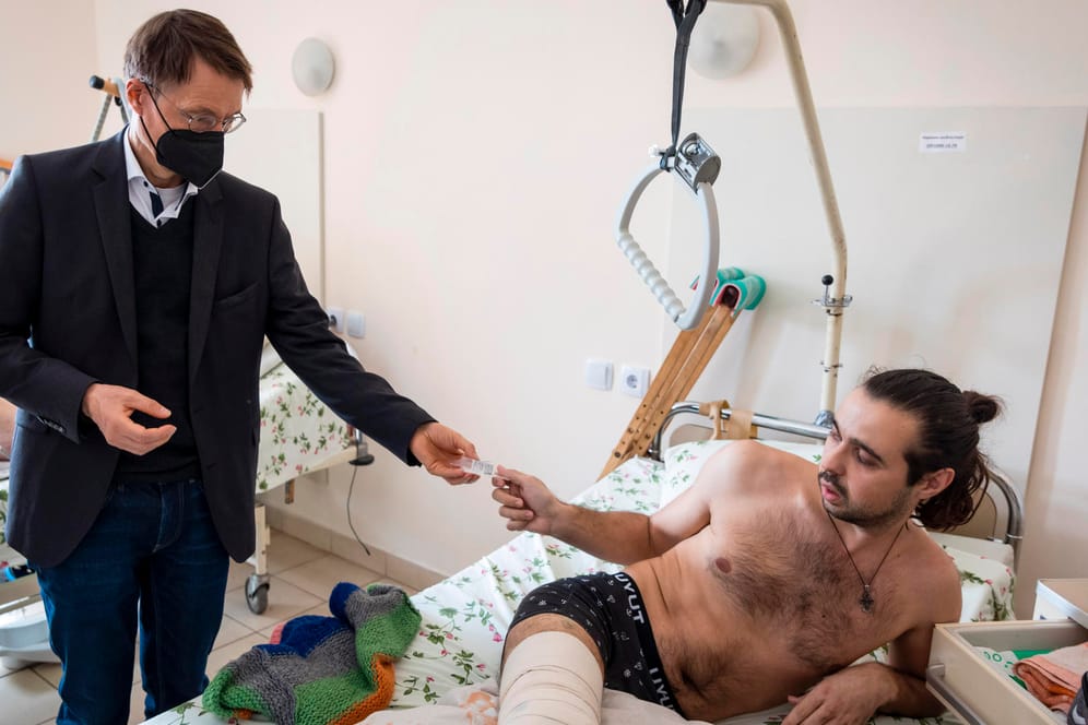 Karl Lauterbach bei einem Kriegsverwundeten in Lwiw: Hier zeigt ihm ein Patient eine Kugel, die sein Bein getroffen hat.