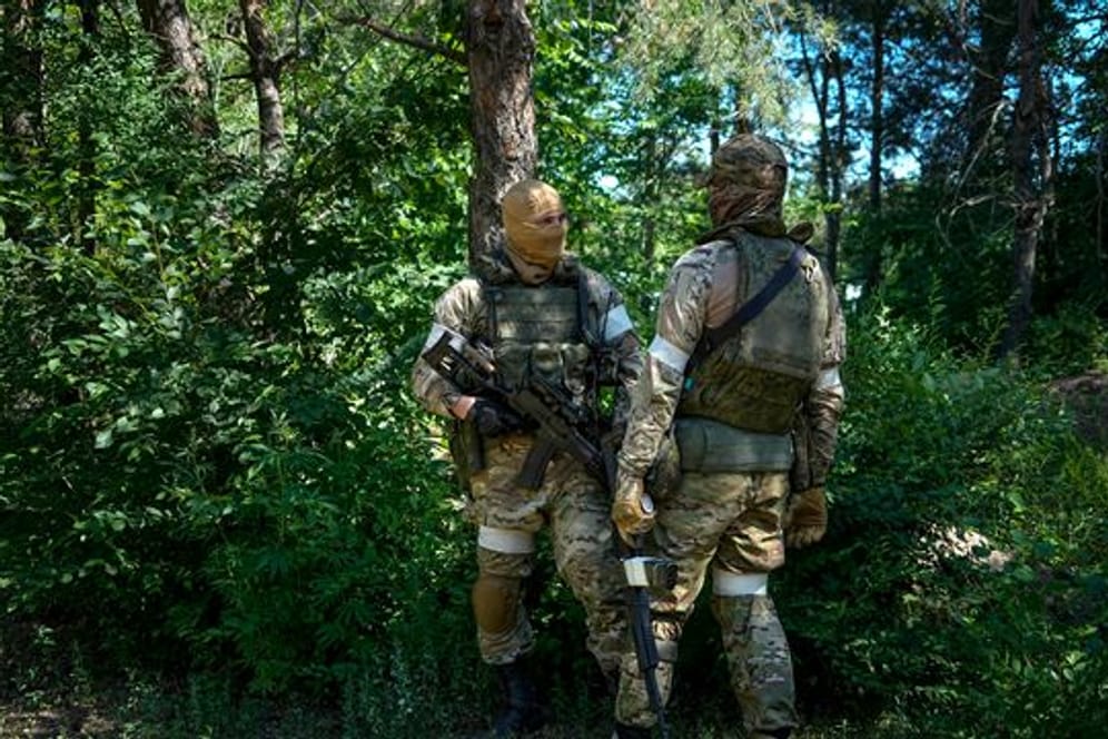 Russische Soldaten bewachen einen Bereich an einem eroberten ukrainischen Kontrollpunkt bei Luhansk (Foto während einer von Russland organisierten Reise aufgenommen).