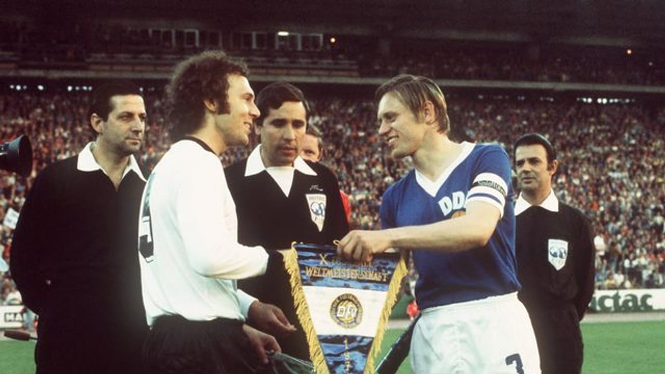 DDR-Auswahl-Kapitän Bernd Bransch (r) 1974 beim Wimpeltausch mit Franz Beckenbauer.
