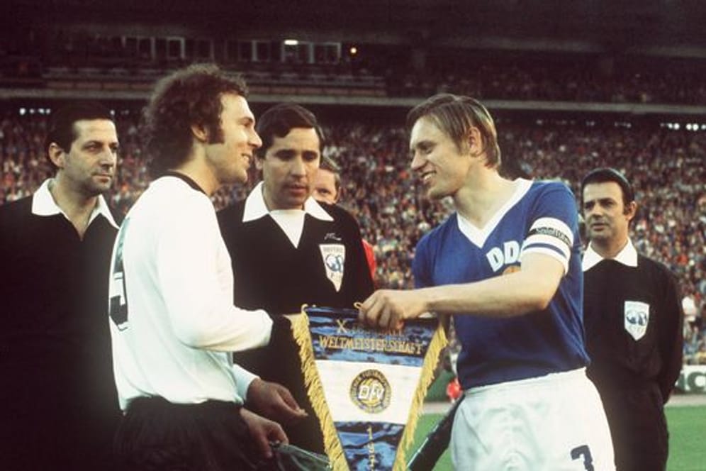 DDR-Auswahl-Kapitän Bernd Bransch (r) 1974 beim Wimpeltausch mit Franz Beckenbauer.
