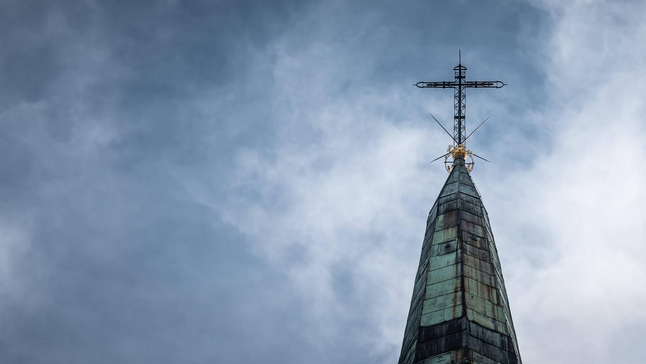 Ein Kirchturm vor dunklen Wolken (Symbolbild): "Die Gottes- und Nächstenliebe wurde pervertiert."