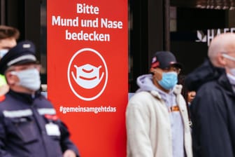 Reisende mit Maske am Düsseldorfer Hauptbahnhof (Archivbild): Nach Pfingsten ist die Zahl der Neuinfektionen deutlich gestiegen.