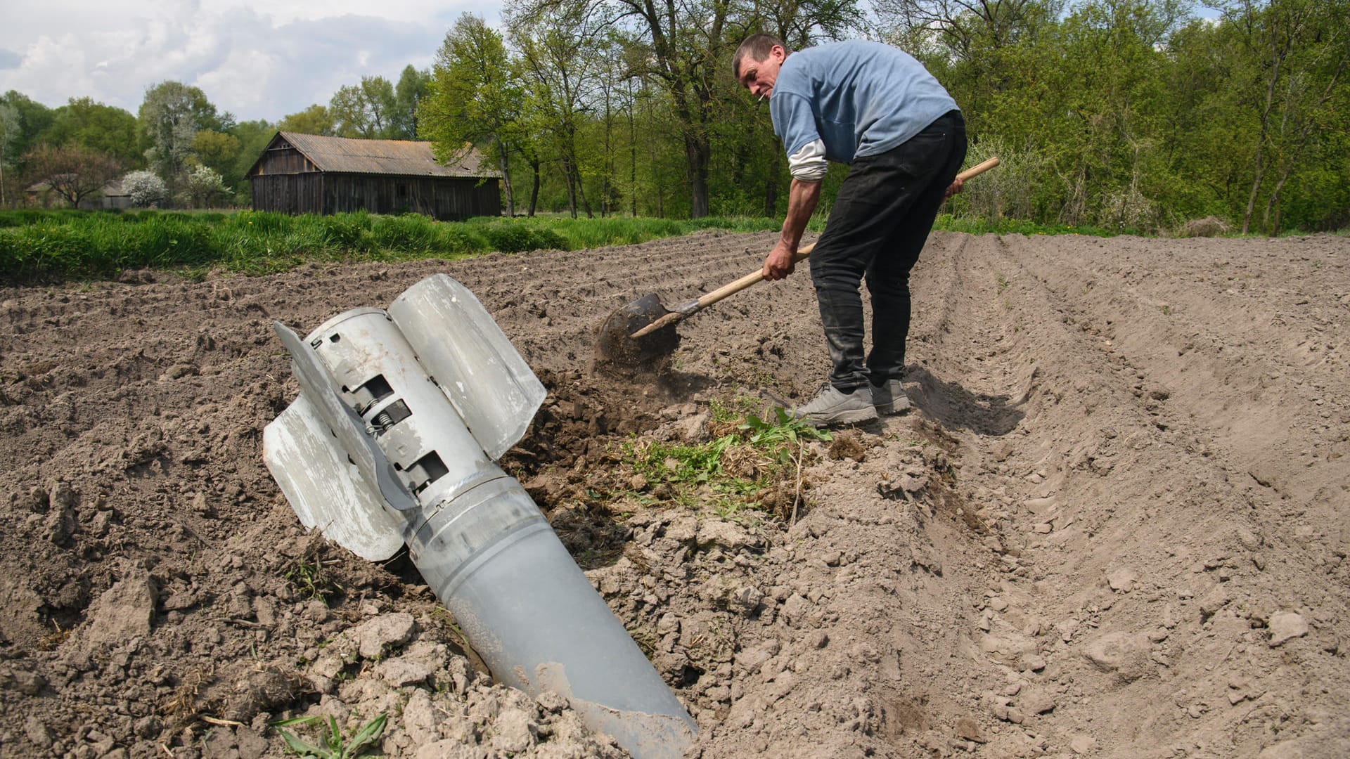 Ivan entfernt eine russische Rakete von seinem Acker in der Region Tschernihiw.