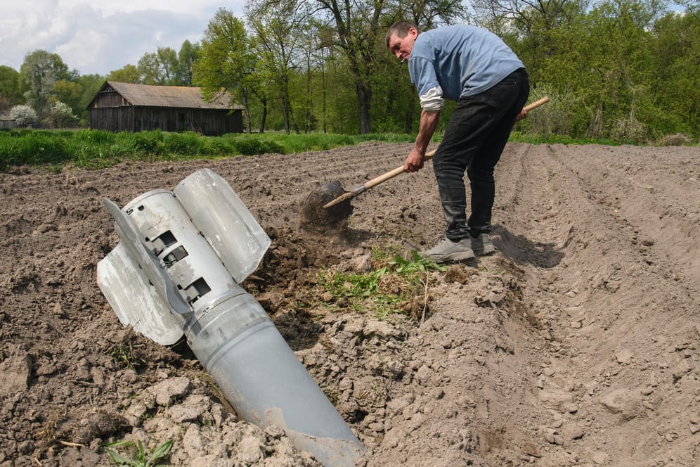 Ivan entfernt eine russische Rakete von seinem Acker in der Region Tschernihiw.