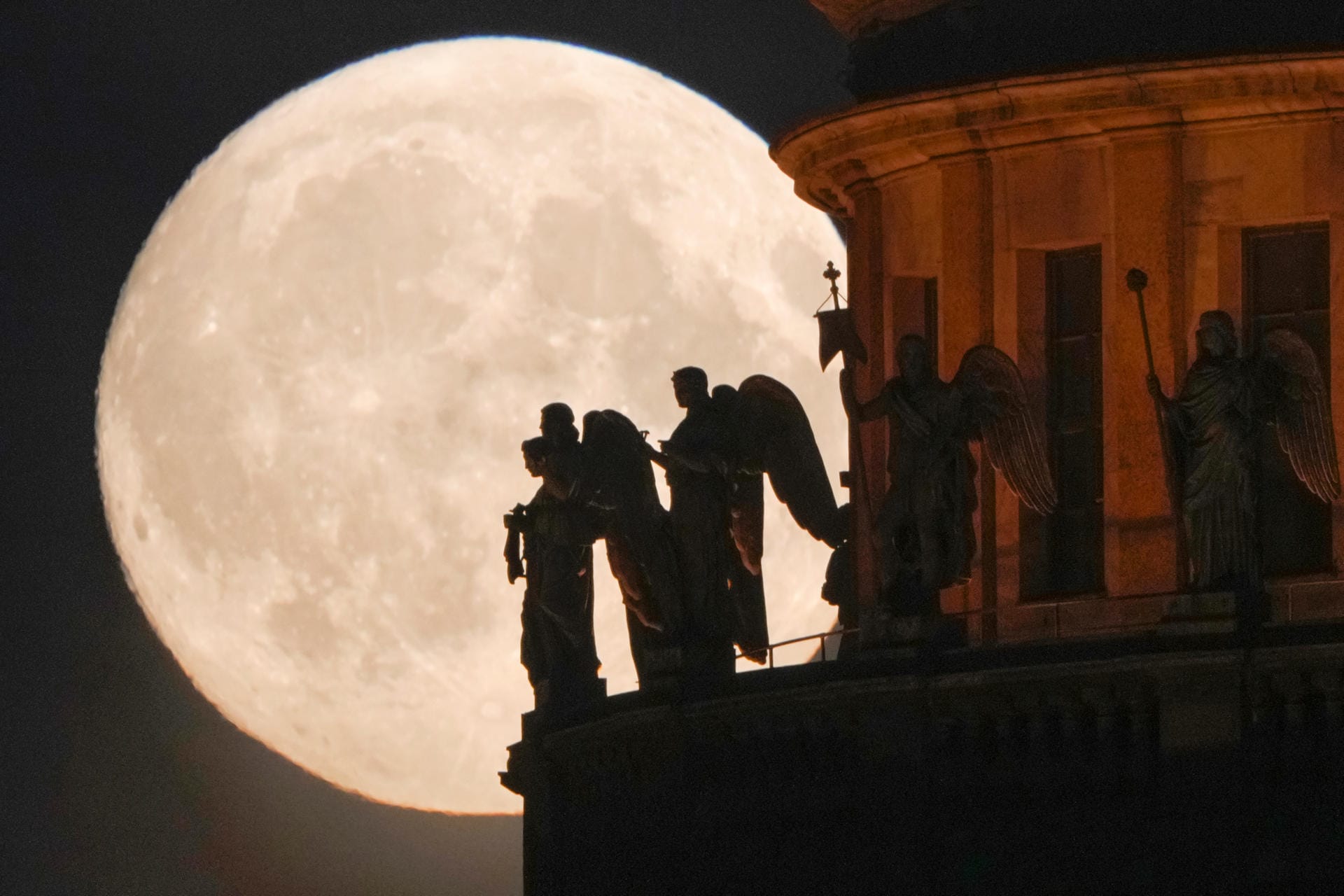 Der Juni-Vollmond hinter Engelsfiguren in St. Petersburg.