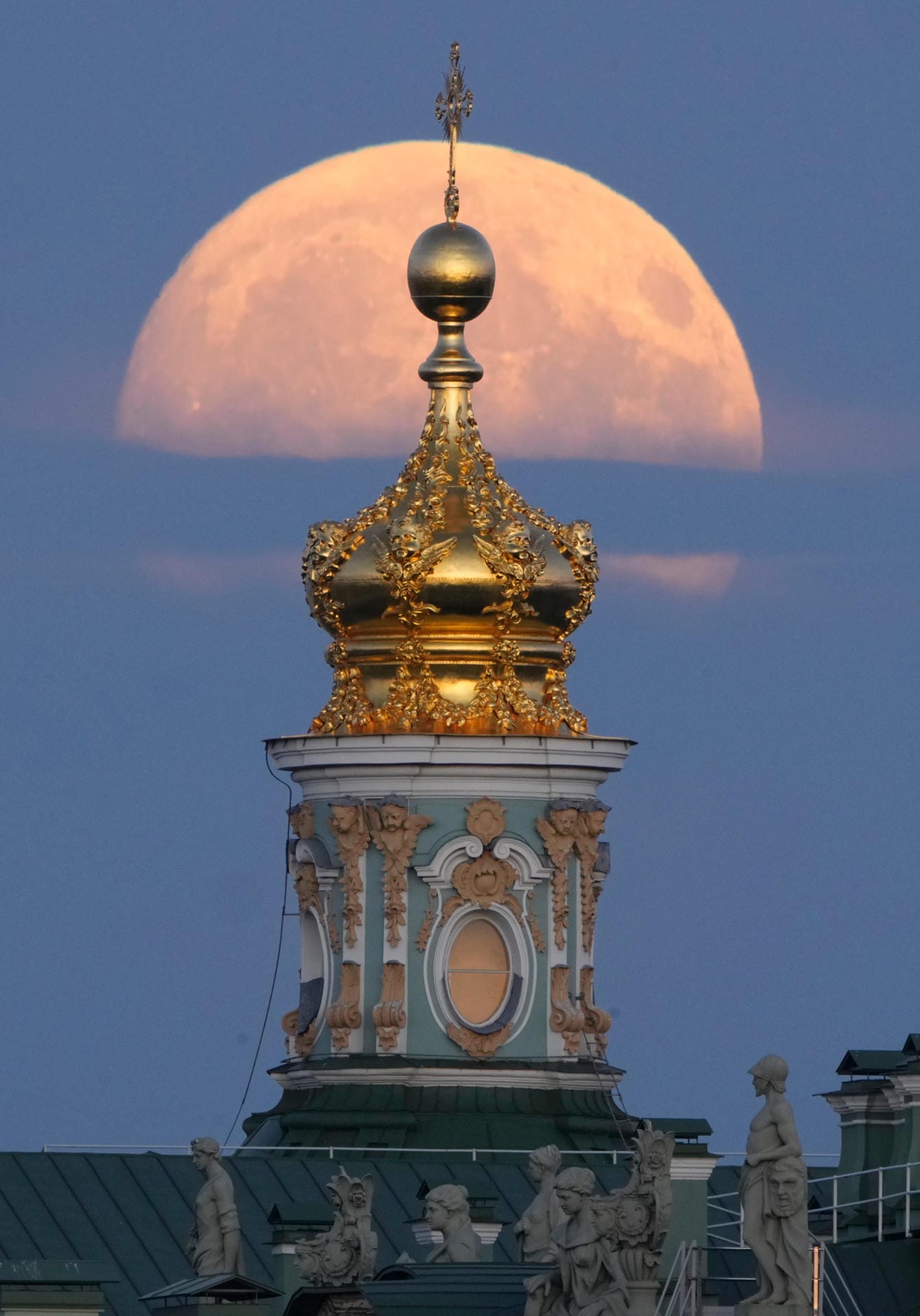 In St. Petersburg (Russland) geht der Supermond hinter einer Kirche auf.