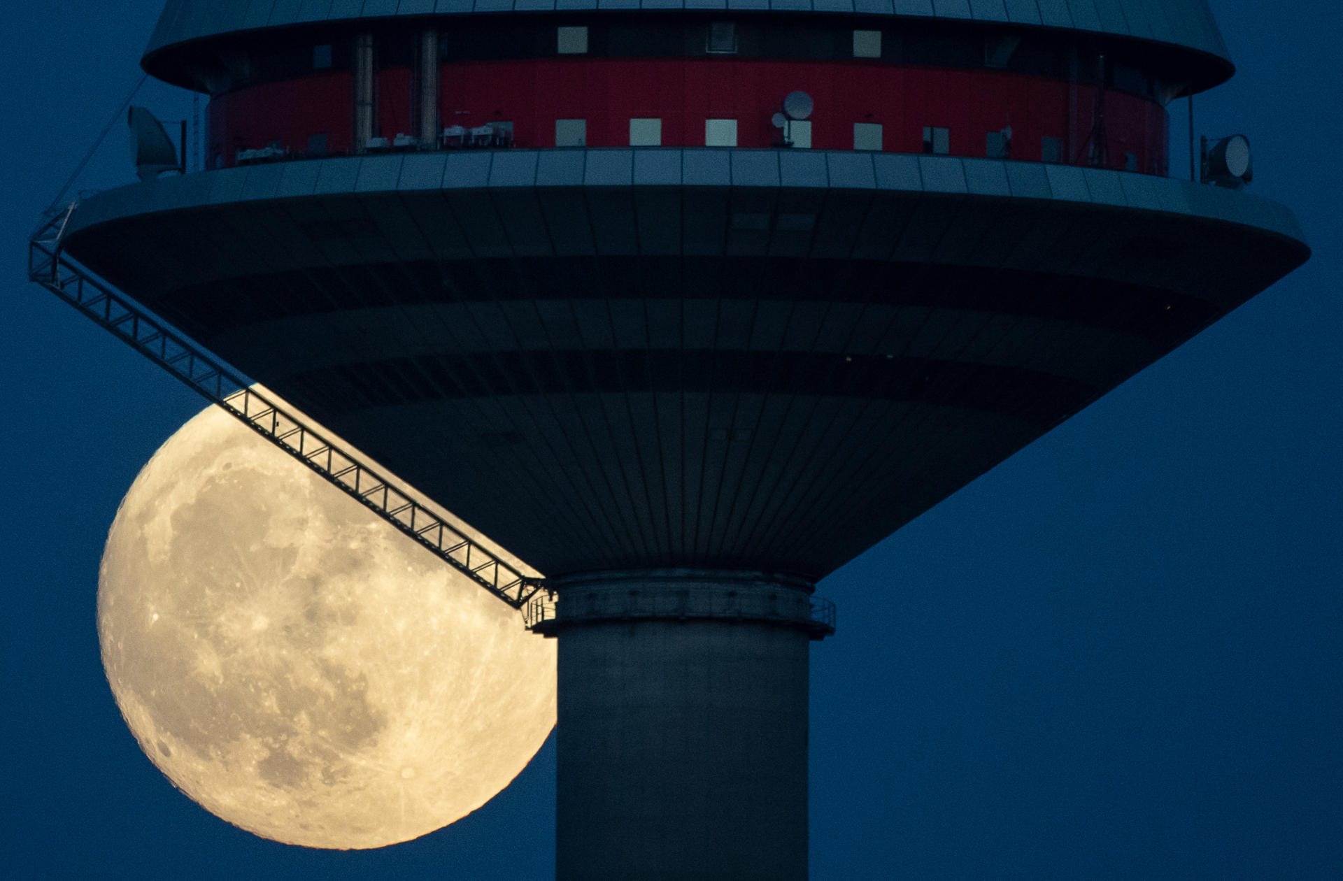 Der Mond steht hinter dem Europaturm in Frankfurt.