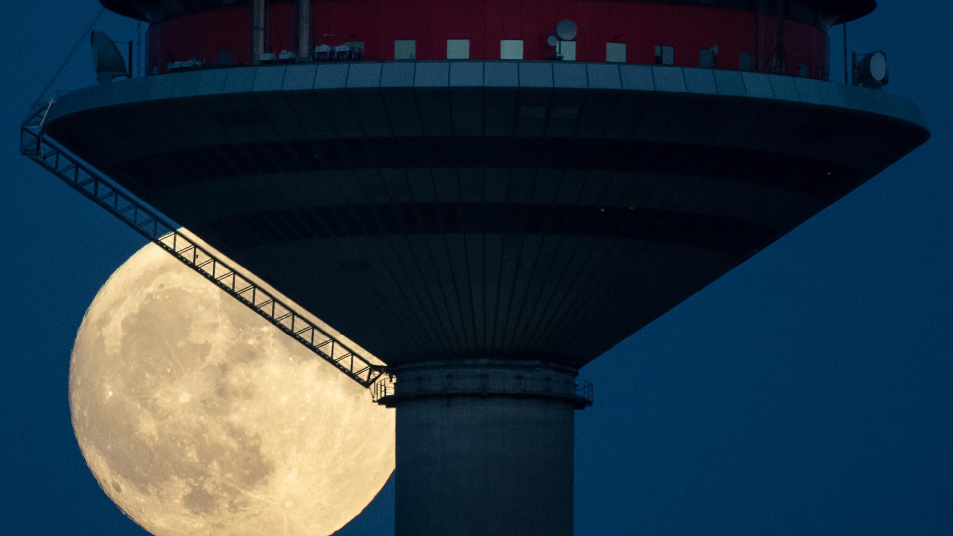 Der Mond steht hinter dem Europaturm in Frankfurt.