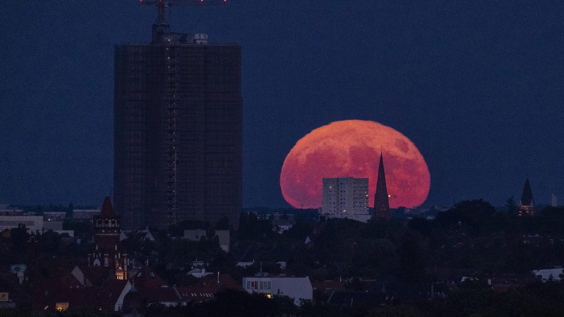 Der sogenannte Erdbeermond zeichnet sich ab beim Aufgang neben dem Steglitzer Kreisel in Berlin.