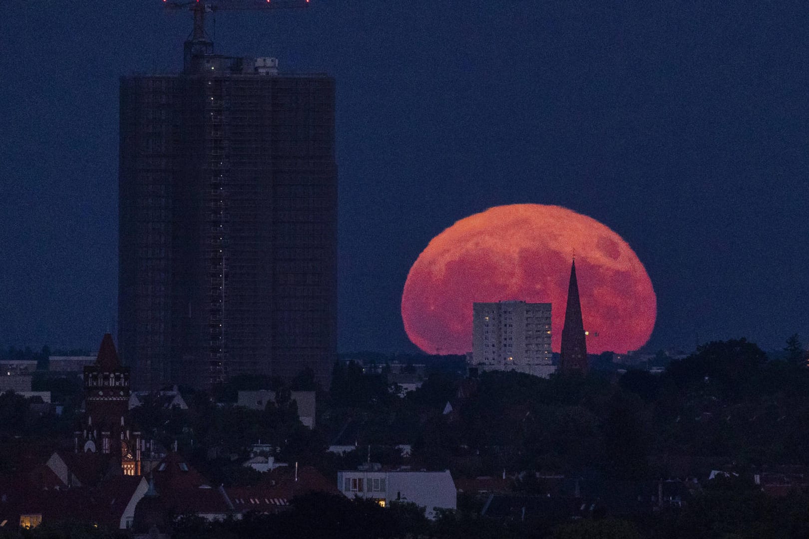 Der sogenannte Erdbeermond zeichnet sich ab beim Aufgang neben dem Steglitzer Kreisel in Berlin.