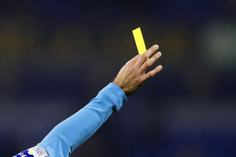 Ein Schiedsrichter zeigt eine gelbe Karte (Symbolbild): In El Salvador bezahlte ein Unparteiischer dafür mit seinem Leben.