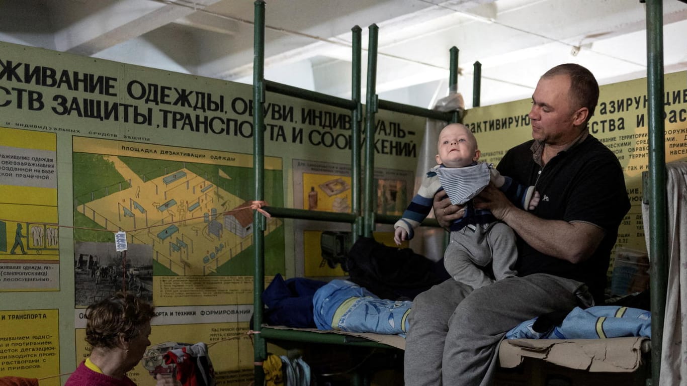 Ein Mann hält sein Kind im Bunker unter dem Asot-Werk: Hunderte hoffen auf Evakuierung.