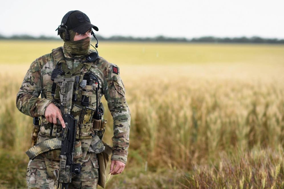 Russischer Soldat vor einem ukrainischen Weizenfeld (Symbolbild): Russland verhindert einen Export ukrainischen Getreides während des Krieges.