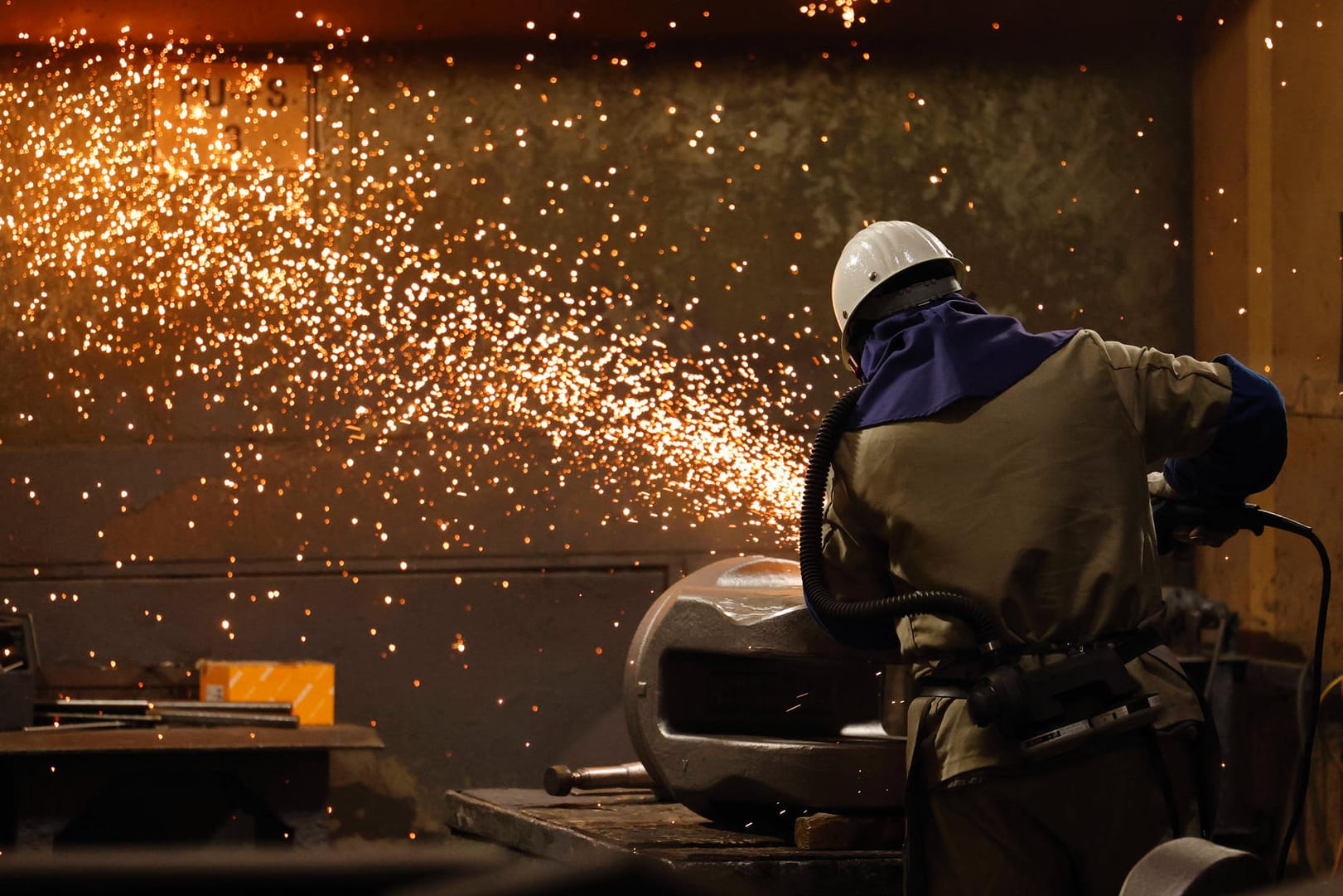 Ein Arbeiter flext ein Stahlbauteil (Symbolbild): Die Gewerkschaft hat angesichts der steigenden Inflation eine deutliche Gehaltssteigerung für Stahlarbeiter durchsetzen können.