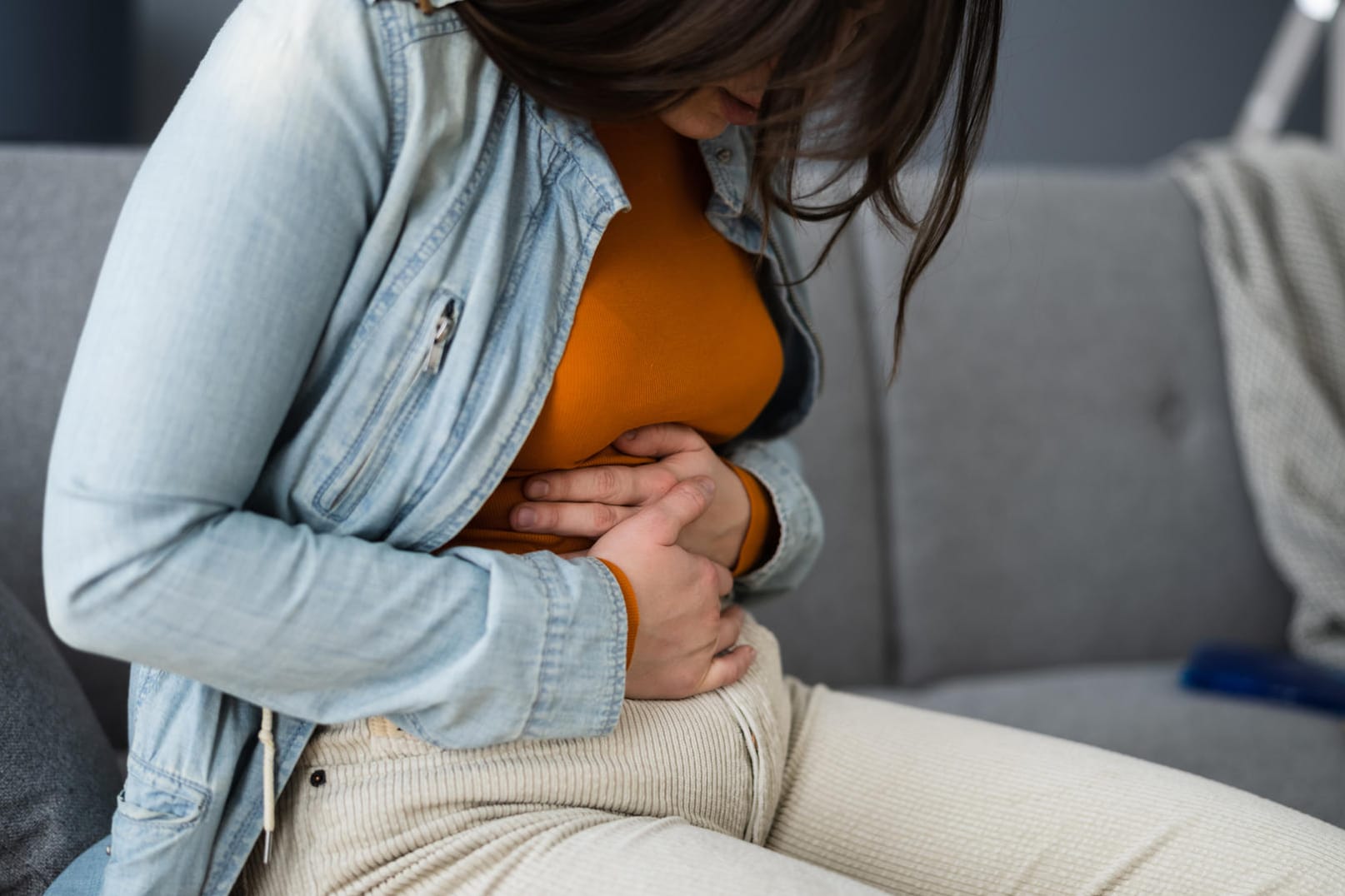 Frau hält sich den Bauch.