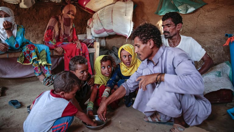 Eine jemenitische Familie teilt sich eine Blätterpaste. Was früher Beilage war, muss inzwischen als Hauptgericht reichen. Weltweit leiden zwei Milliarden Menschen unter Mangelernährung.