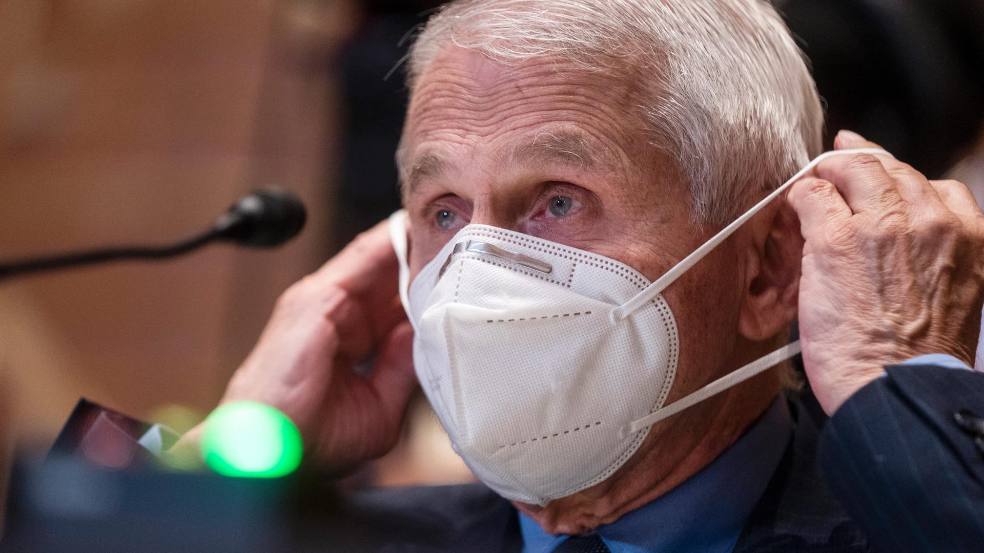 Anthony Fauci zieht sich eine Maske über (Archivbild): Trotz Vorsicht und Impfungen hat er sich jetzt auch infiziert.