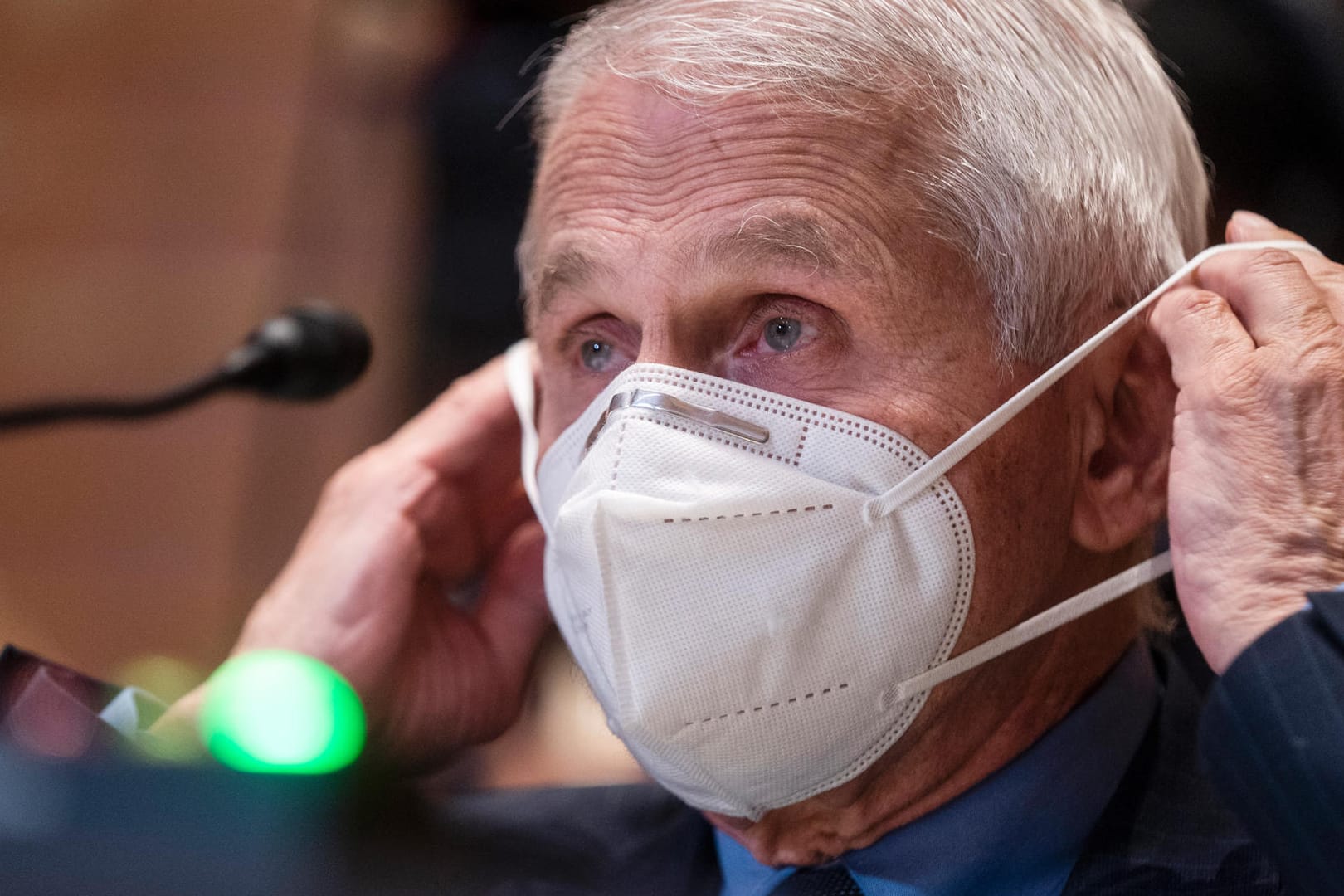 Anthony Fauci zieht sich eine Maske über (Archivbild): Trotz Vorsicht und Impfungen hat er sich jetzt auch infiziert.