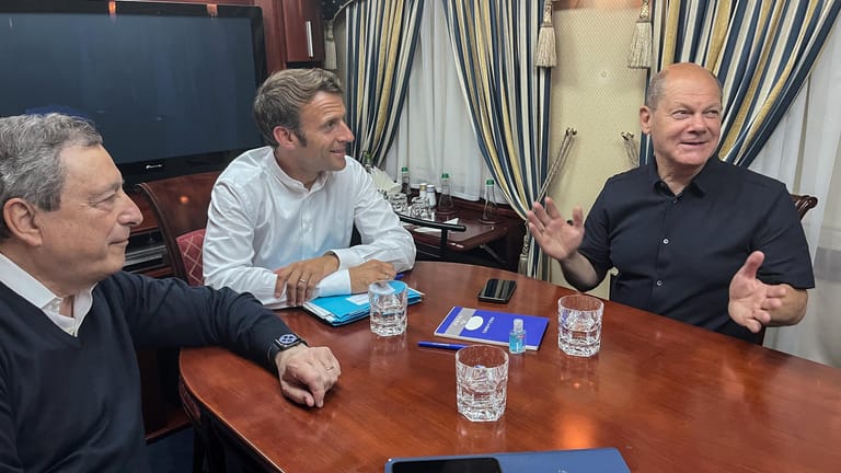 Italiens Ministerpräsident Mario Draghi (l-r), Frankreichs Präsident Emmanuel Macron und Bundeskanzler Olaf Scholz (SPD) sitzen in einem Zug auf der Reise nach Kiew.