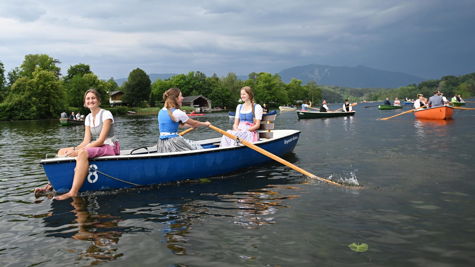 Bayern, Seehausen am Staffelsee: Eine junge Frau hält bei der Seeprozession ihre Füße in den Staffelsee.