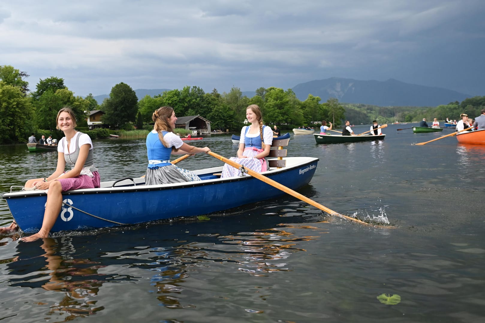 Bayern, Seehausen am Staffelsee: Eine junge Frau hält bei der Seeprozession ihre Füße in den Staffelsee.