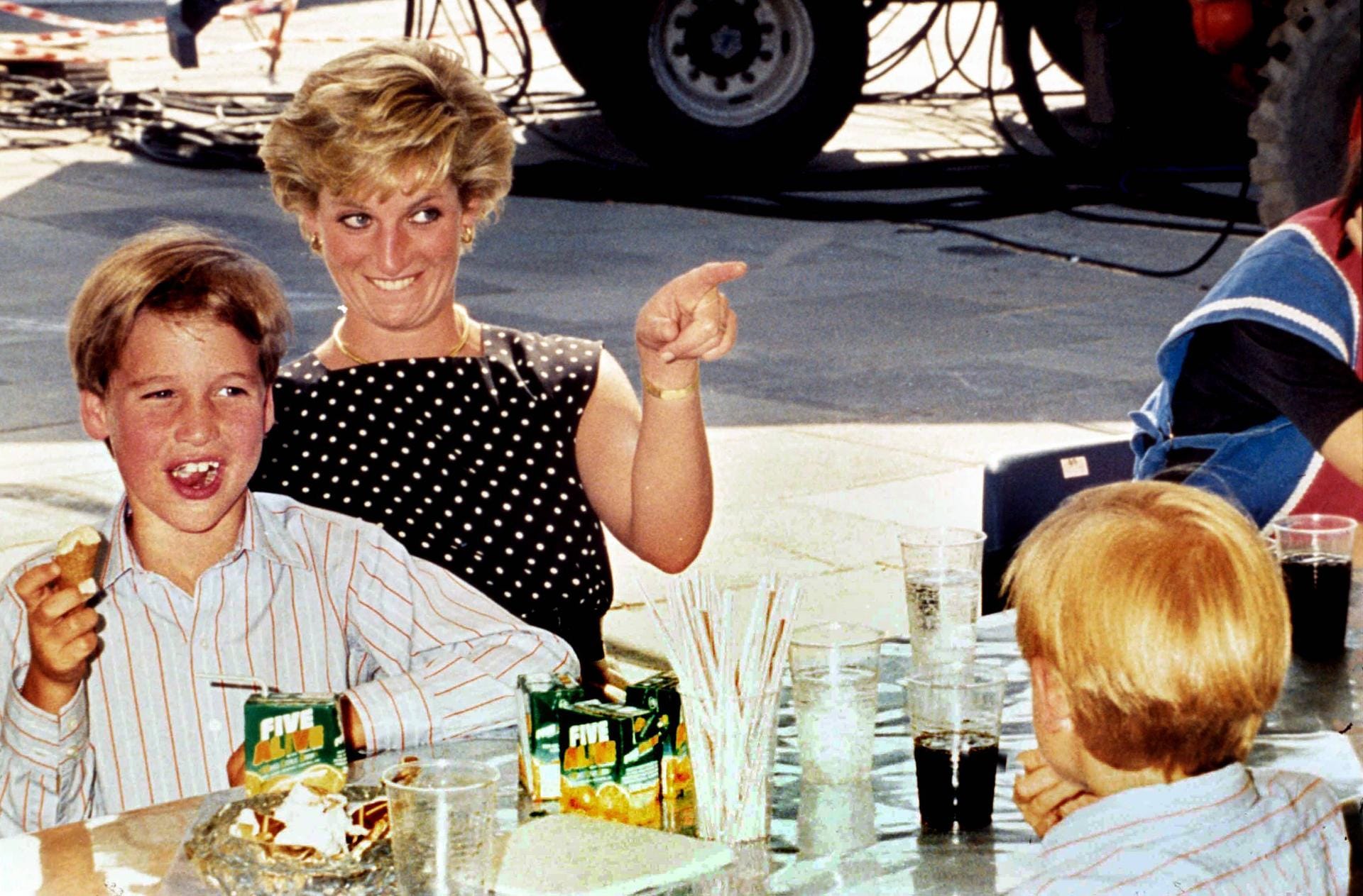 Prinzessin Diana mit ihrem Sohn William, von hinten ist Prinz Harry im Bild zu sehen.