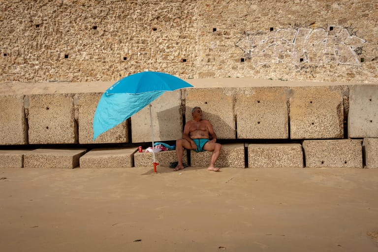 Cádiz in Spanien: In der südwestlich gelegenen Hafenstadt schützt sich ein Mann unter seinem Sonnenschirm vor der Hitze. Die höchsten Temperaturen wurden für Andalusien im Süden des Landes vorhergesagt.