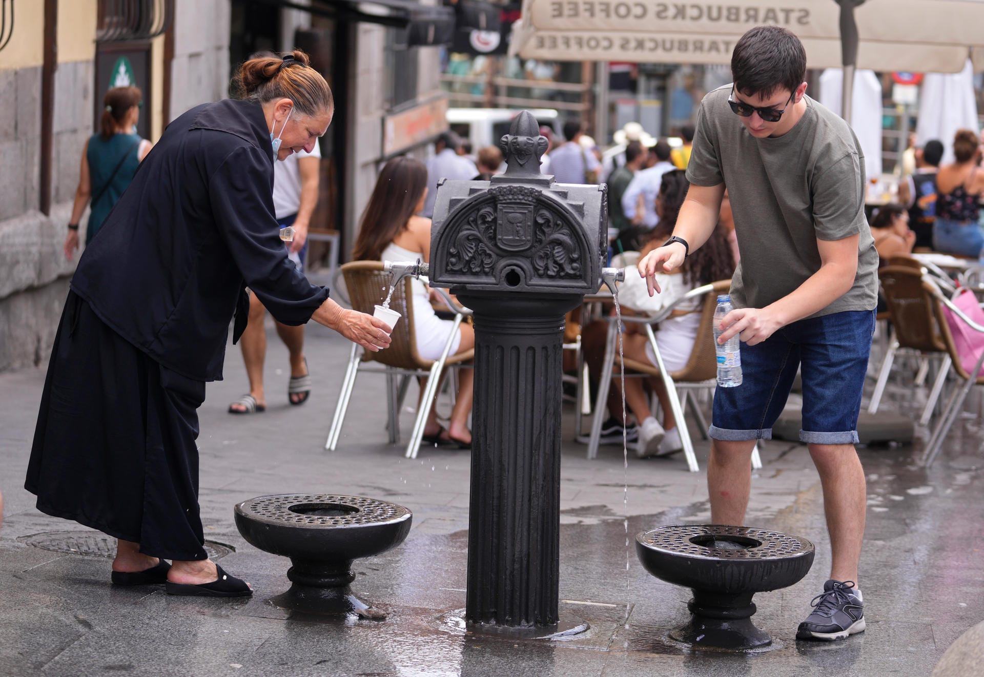 In der spanischen Hauptstadt Madrid füllen sich Menschen Wasser an öffentlichen Trinkbrunnen ab: Derzeit löst heiße Luft aus Nordafrika die erste große Hitzewelle des Jahres in Südwesteuropa aus.