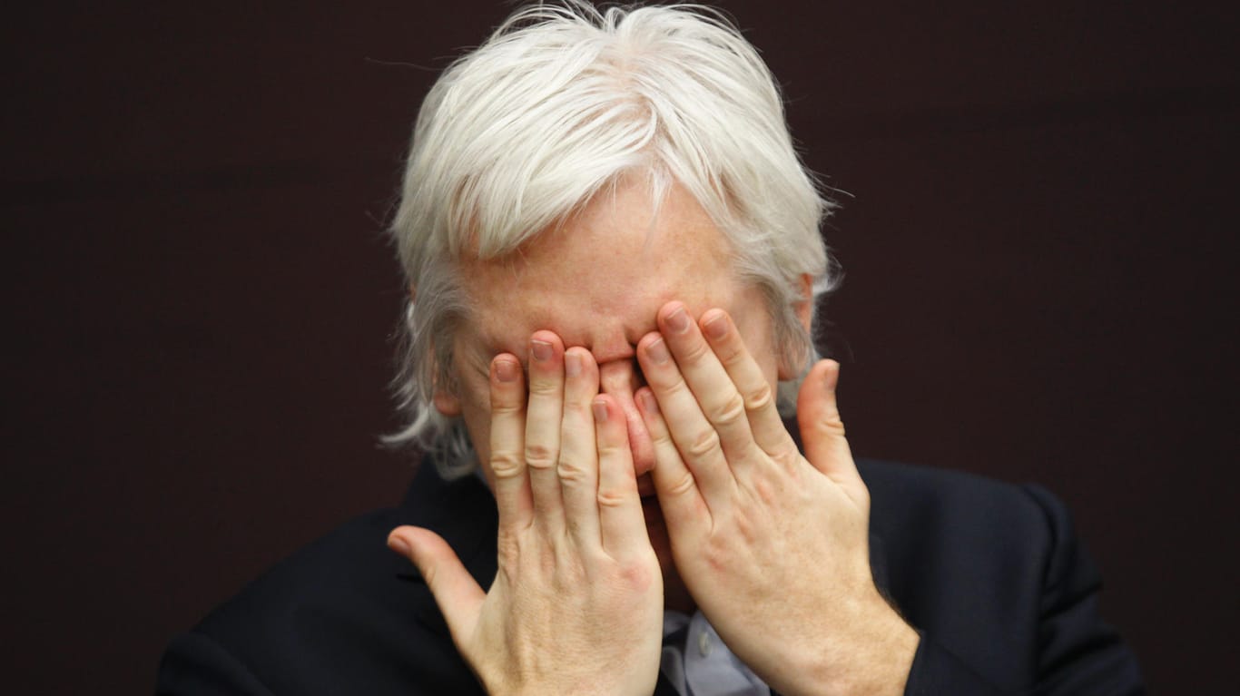 Julian Assange hält sich die Hände vors Gesicht: Der Gründer der Enthüllungsplattform wehrt sich schon seit mehr als zehn Jahren gegen eine mögliche Überstellung in die USA.