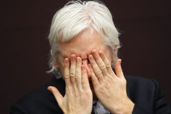 Julian Assange hält sich die Hände vors Gesicht: Der Gründer der Enthüllungsplattform wehrt sich schon seit mehr als zehn Jahren gegen eine mögliche Überstellung in die USA.