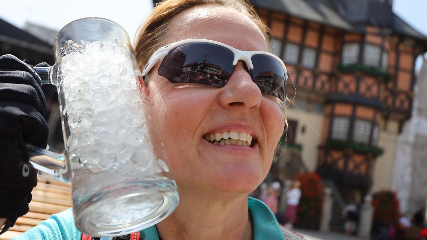 Eine Frau kühlt sich mit einem Glas voller Eiswürfel ab: Das heiße Wetter führte am Wochenende zu neuen Hitzerekorden in Sachsen.