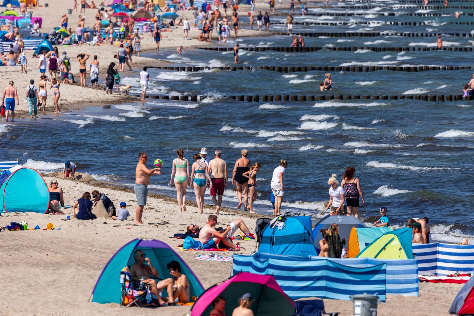 Urlauber und Tagesgäste an der Ostsee in Warnemünde: Das Sommerwetter sorgt für gut besuchte Strände.