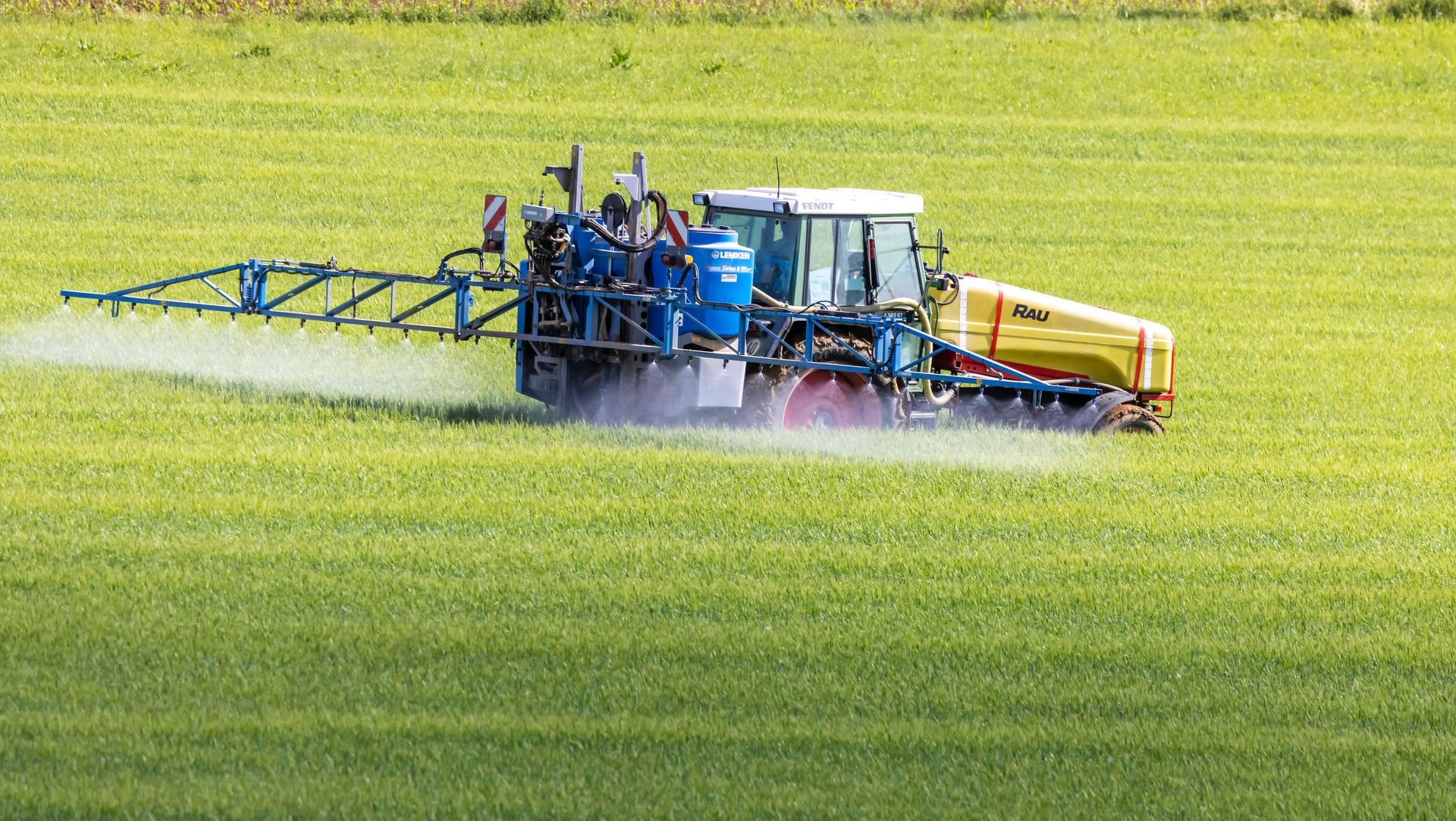 Ein Landwirt mit Traktor düngt sein Feld (Symbolbild): Die Erzeugerpreise sind im Mai so stark gestiegen wie noch nie.