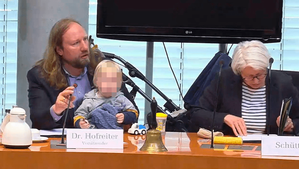 Hofreiter mit Kind: Der Kinderwagen steht im Hintergrund.