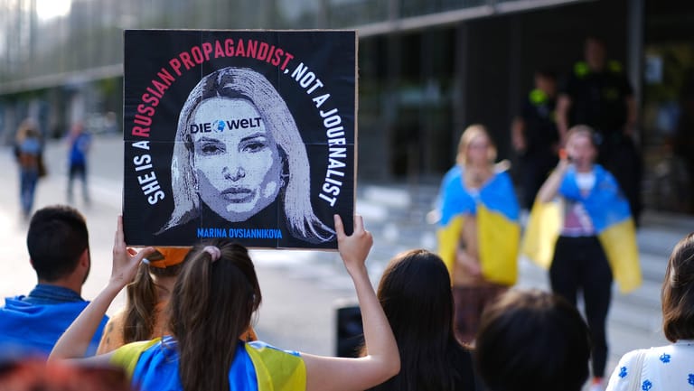 In Berlin demonstrieren ukrainische Demonstranten vor dem Axel-Springer-Verlag gegen Marina Owsjannikowa. Der Sender "Welt" hatte sie als Korrespondentin gewonnen; inzwischen ist sie dort nicht mehr tätig.