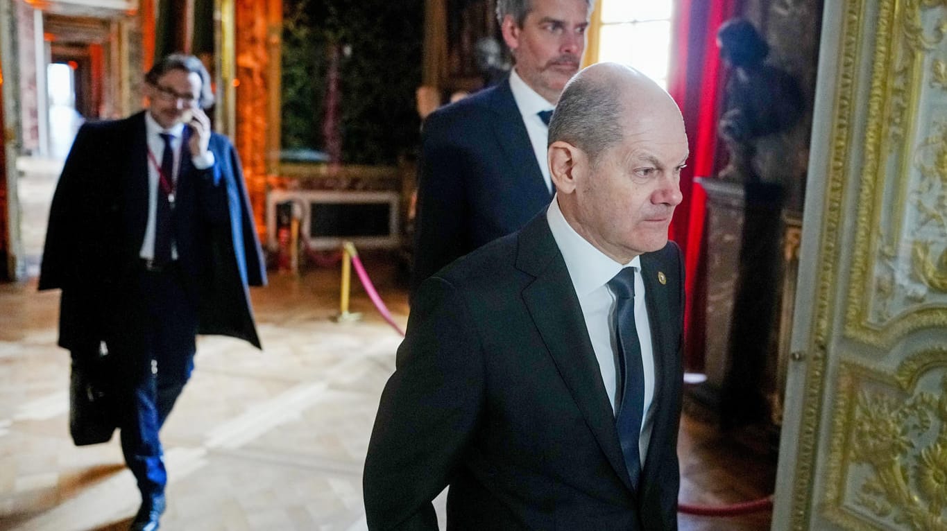 Olaf Scholz (SPD) kommt beim Treffen der Staats- und Regierungschefs der EU mit seinem Sprecher Steffen Hebestreit (M.) und Jens Plötner (l.) ins Schloss Versailles bei Paris.